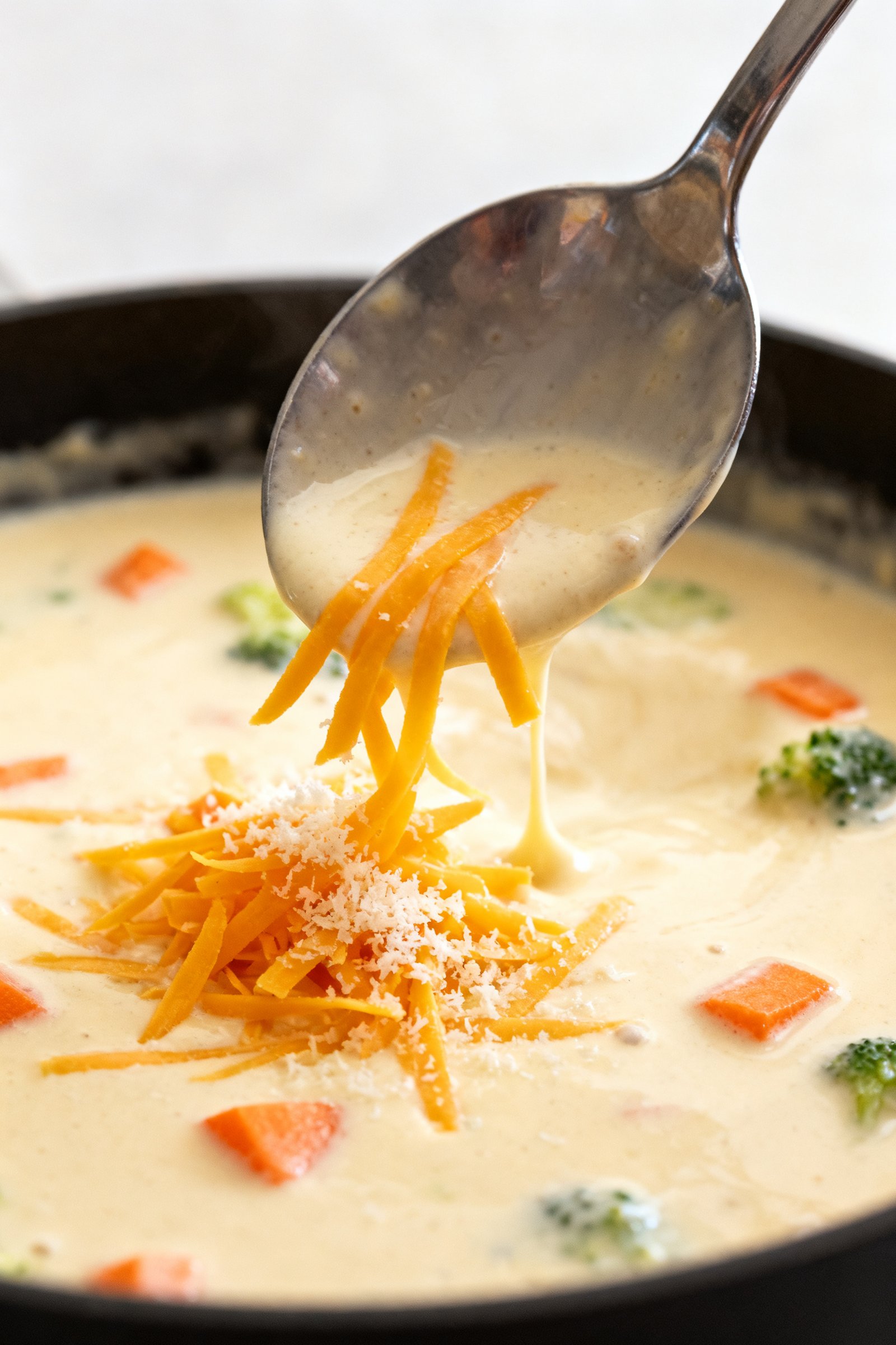 Close-up detail — cheese-melt moment: Tight close-up of the off-heat melt step, a glossy ladle of